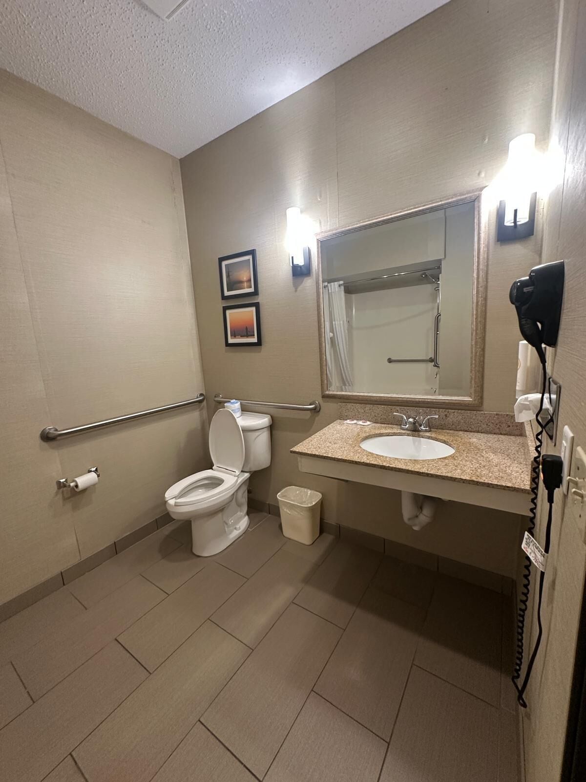 A standard hotel bathroom with a toilet, sink, and shower.