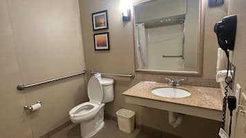 A standard hotel bathroom with a toilet, sink, and shower.