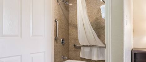 Un baño con ducha, inodoro y bañera.