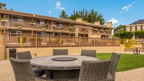 Un hotel con un patio que tiene una mesa redonda y sillas de mimbre.