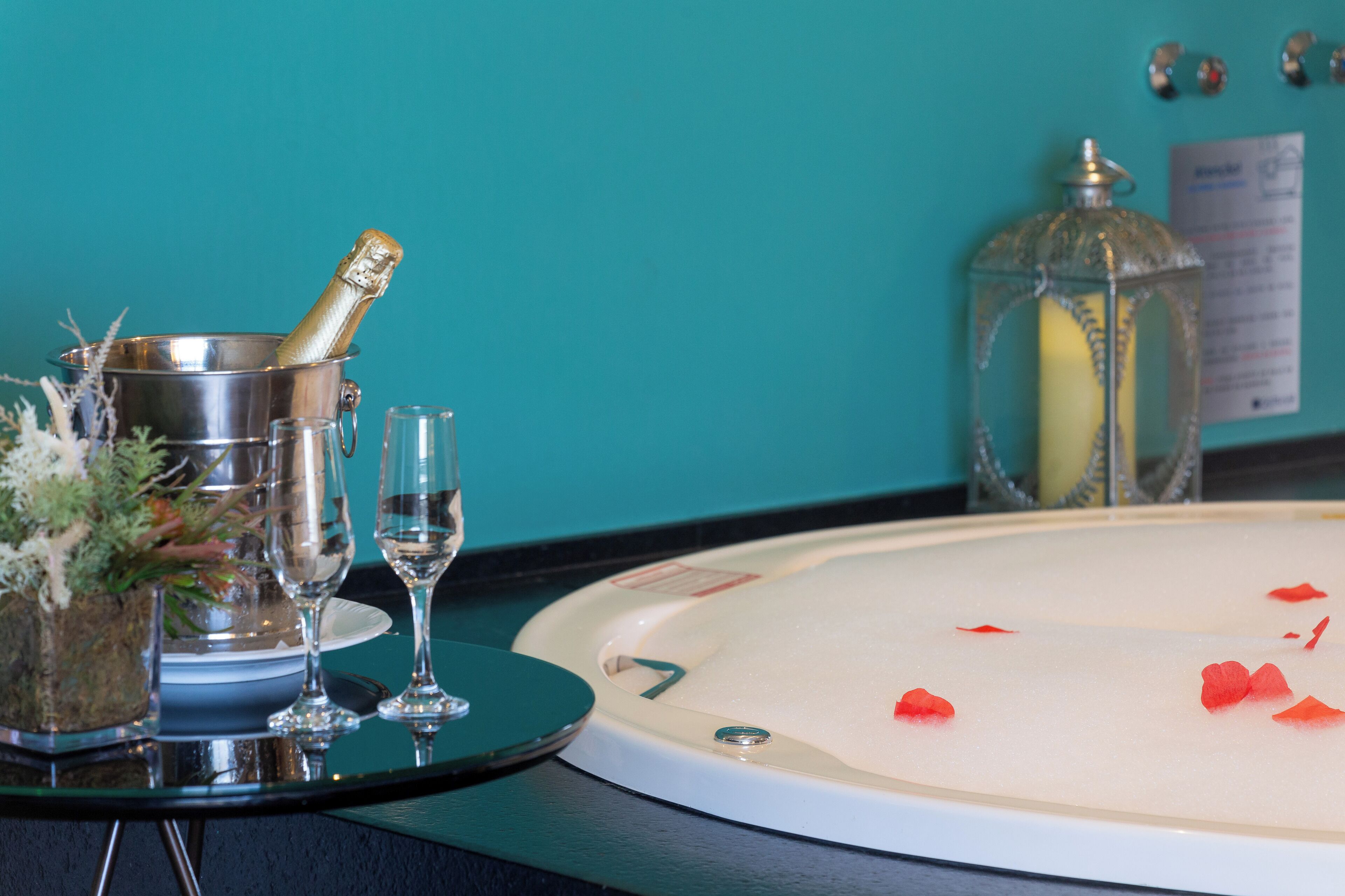 A bar area with a champagne bucket, glasses, and a decorative lantern.