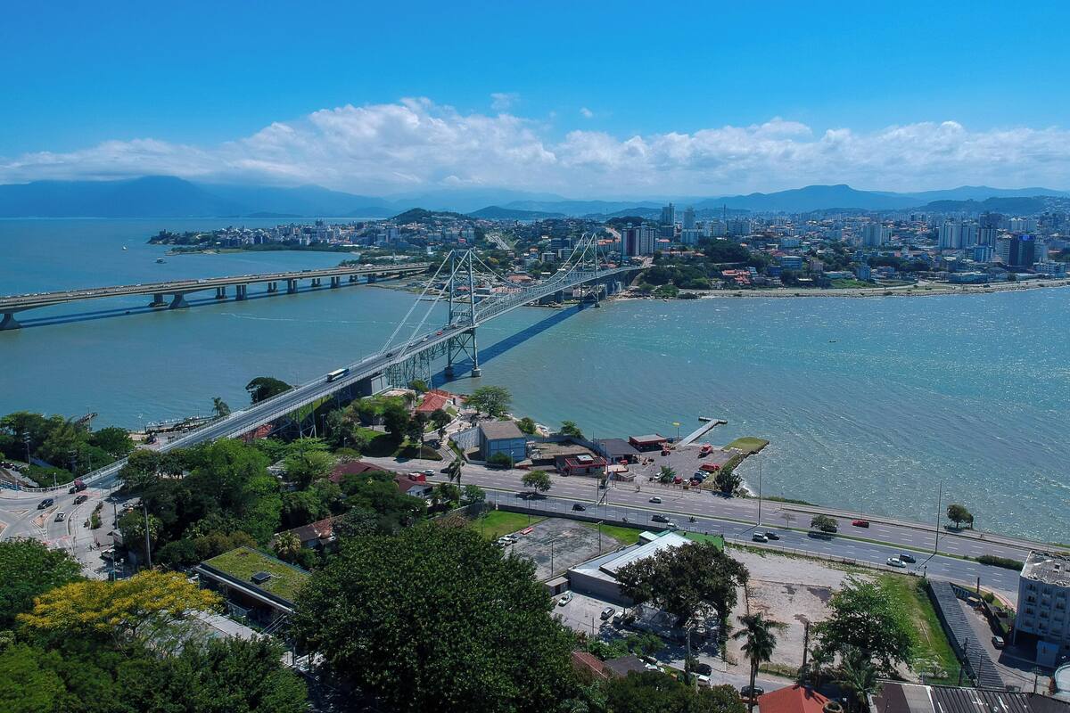 Une vue urbaine mettant en scène un pont imposant qui enjambe une rivière, entouré de bâtiments et de verdure.