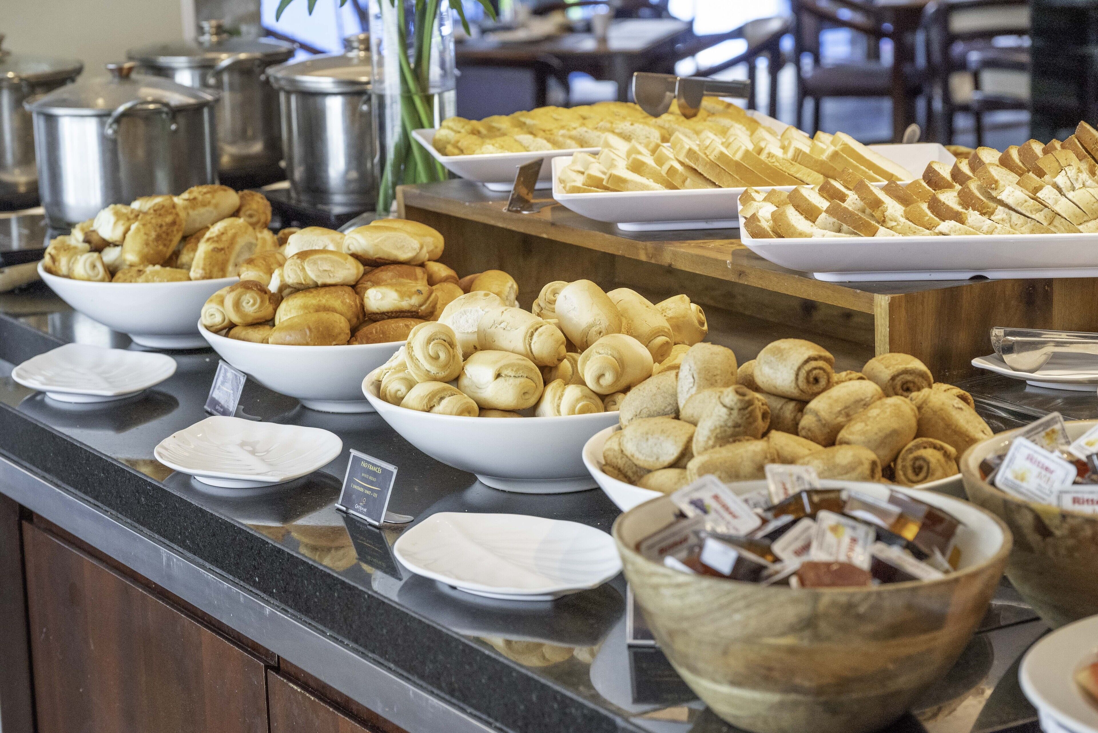 Buffet com diversos alimentos, incluindo pastelaria e sanduíches.