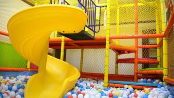 Kids can play and climb in this enclosed play area featuring a spiral slide and ball pit.