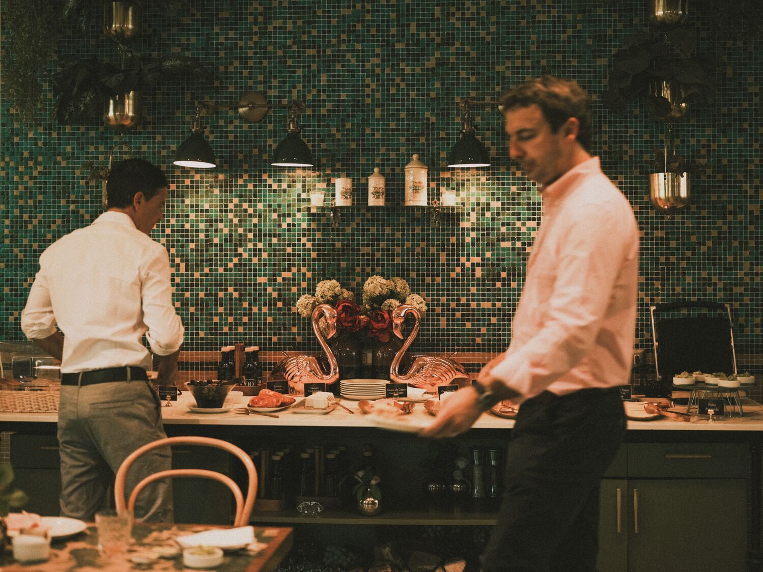 Una cocina con salpicadero de azulejos, un centro de mesa con forma de cisne y varios utensilios de cocina sobre la encimera.