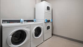 Une buanderie équipée de deux machines à laver à chargement frontal et d’un sèche-linge superposé.