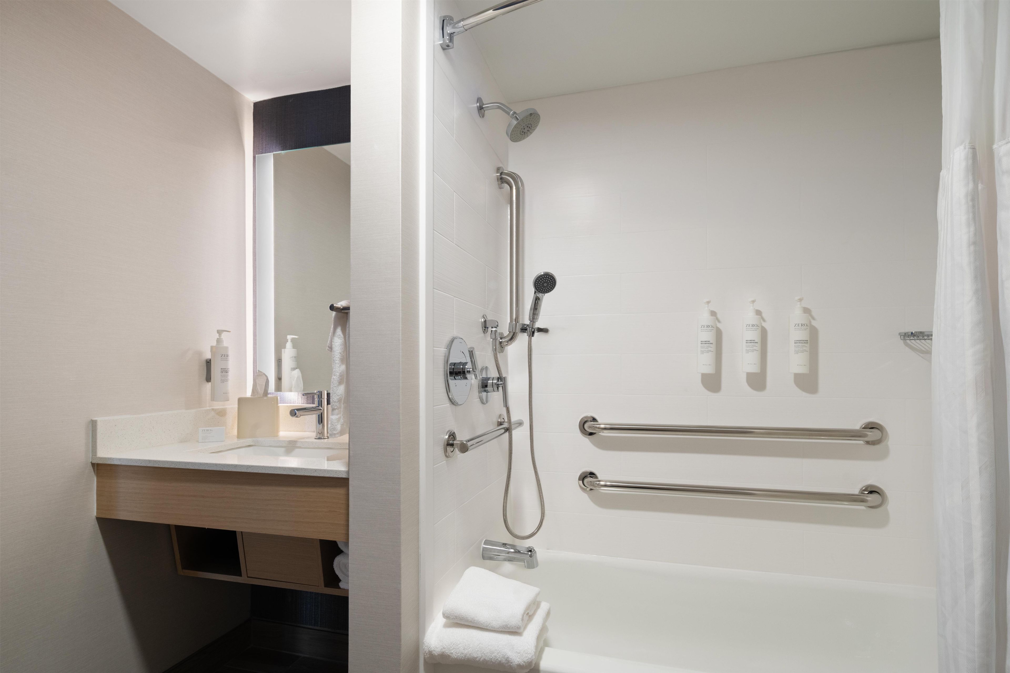 A modern bathroom with a shower, toilet, and sink.