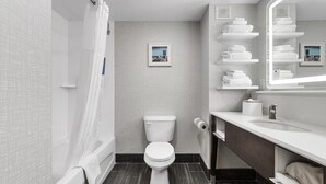 A modern bathroom with a toilet, shower, and vanity.