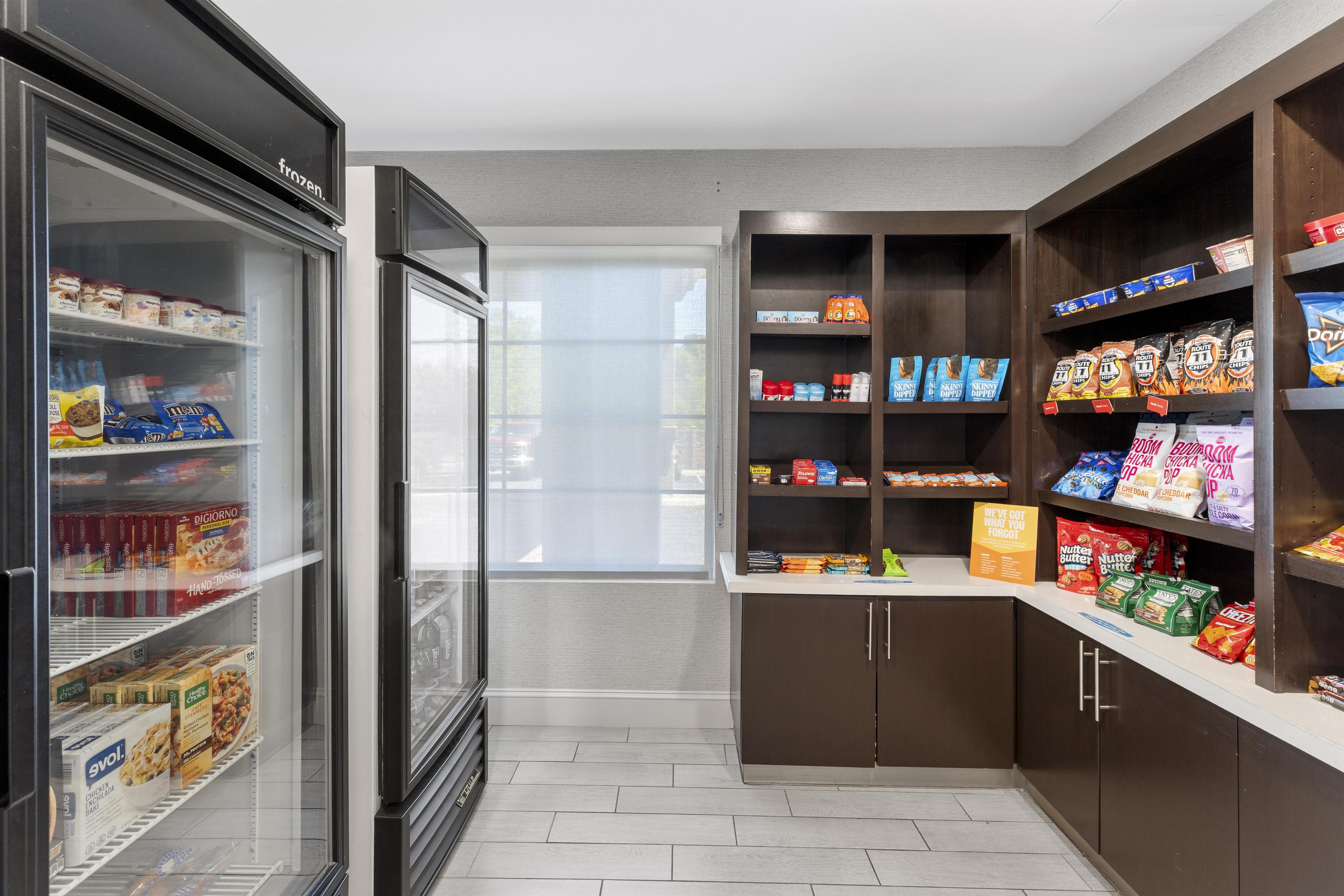 A self-service snack area with refrigerated and non-refrigerated shelves stocked with various food items.