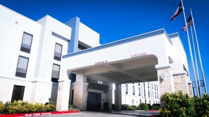 A modern building with a 'WELCOME' sign and a 'CLEARANCE 14'' sign. - Hampton Inn & Suites Houston Katy (Katy)
