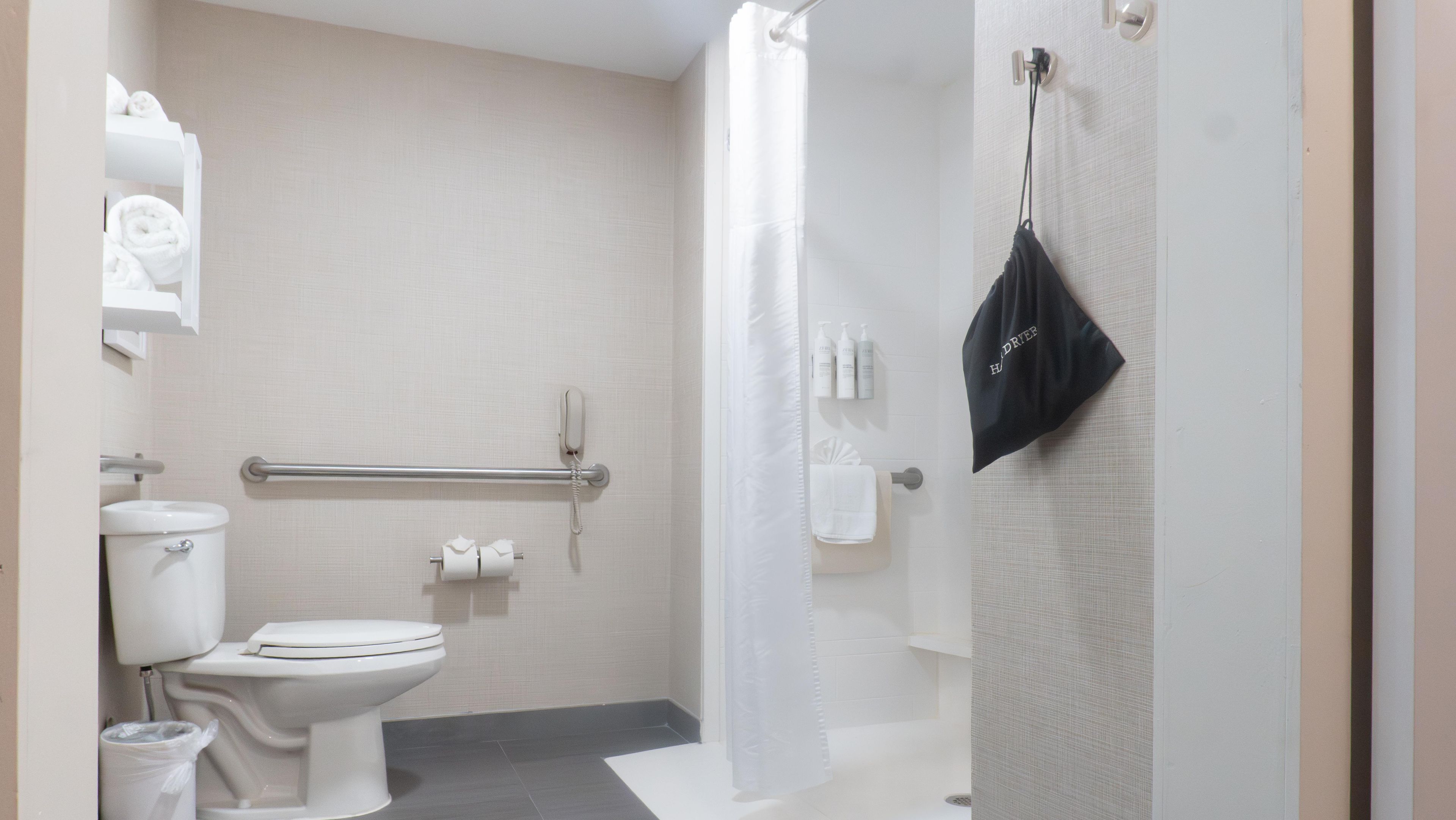 A bathroom with a toilet, bidet, towel rack, and a shower curtain.