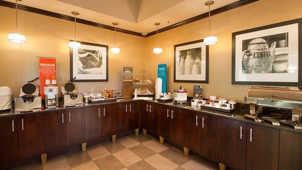 A hotel kitchen with a buffet setup, including various food stations and a coffee machine.