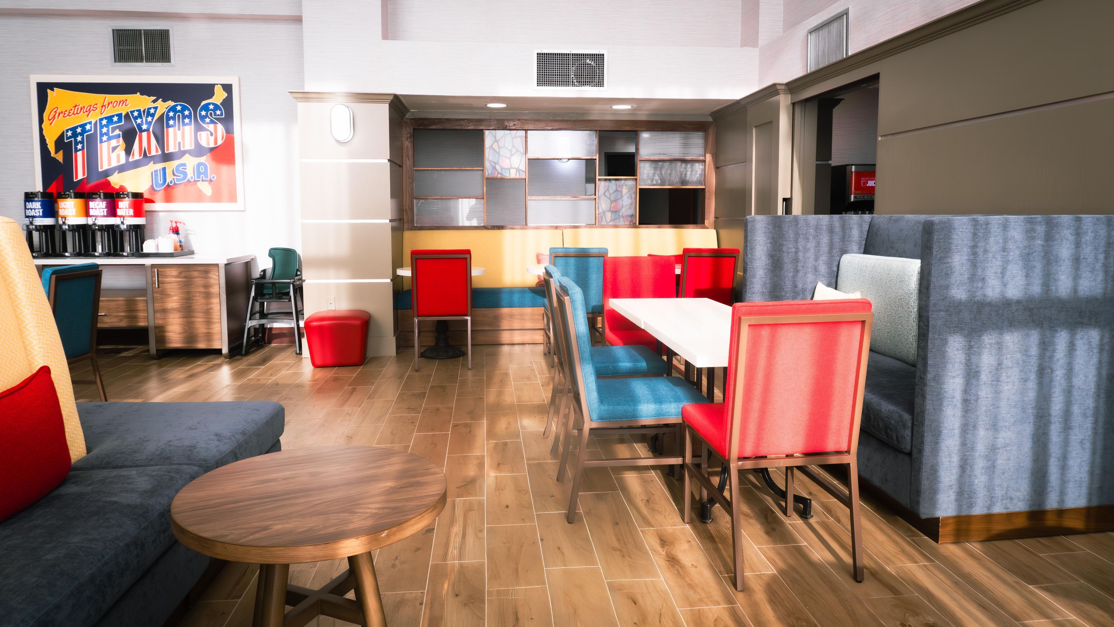 Een modern restaurantinterieur met een bar, zitplaatsen en een grote wanddecoratie.