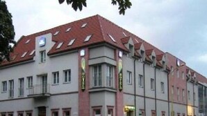 A hotel with a red-tiled roof, multiple windows, and a sign indicating it is a hotel. - Teledom Hotel & Conference Center (Kosice)