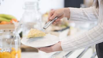 A person serving a slice of cake on a white plate.