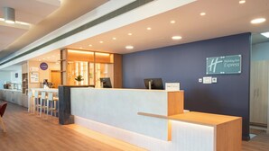 A hotel reception area with a reception desk, seating area, and a sign for Holiday Inn Express. - Holiday Inn Express Valencia - Bonaire by IHG (Quart de Poblet)