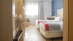 A hotel room with two beds, a desk, a chair, a lamp, and a phone. - Holiday Inn Express Valencia - Bonaire by IHG (Quart de Poblet)