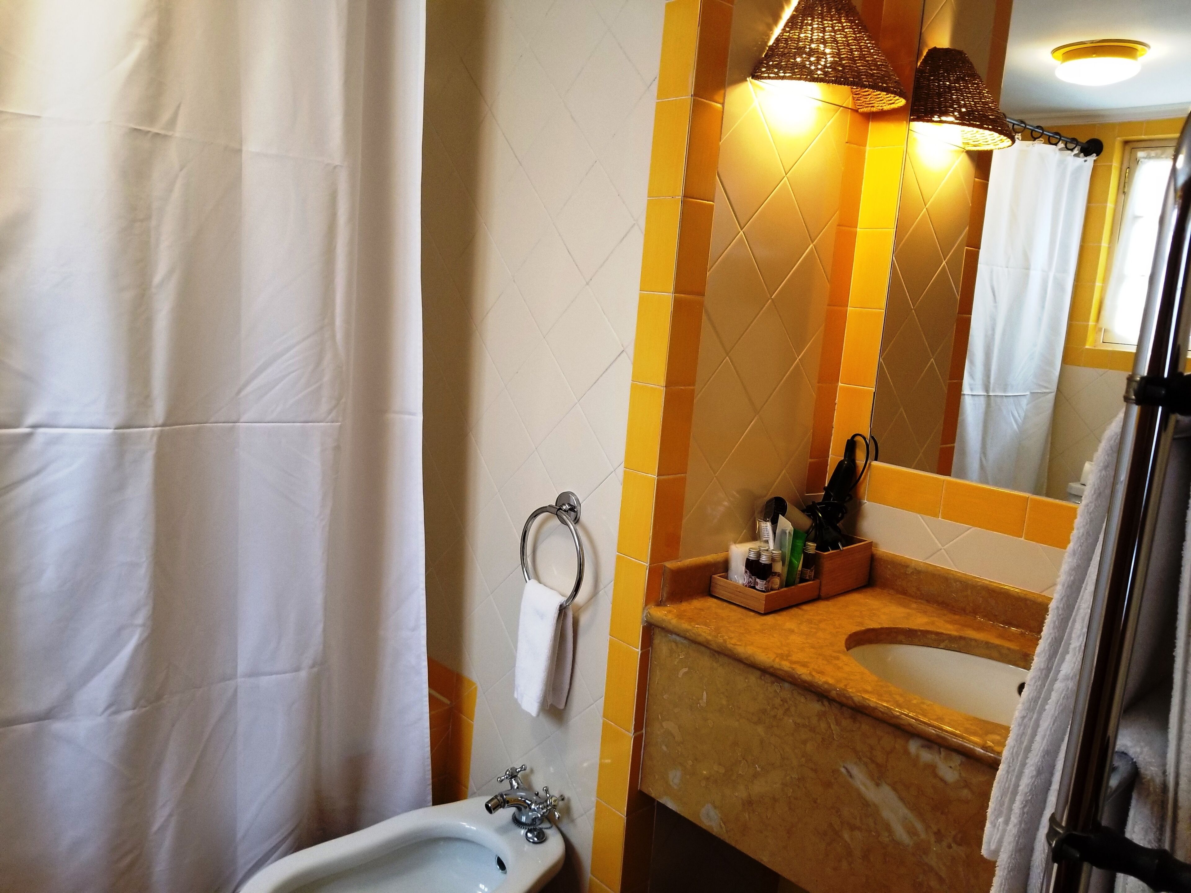 A bathroom with a white sink, a mirror, and a towel rack.