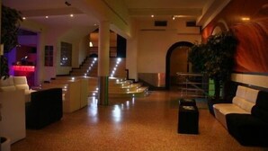 A spacious lobby with a staircase, seating areas, and a decorative wall. - Quinta dos Três Pinheiros (Mealhada)