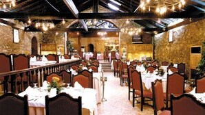 A banquet hall with long tables, chairs, and a high ceiling with exposed beams. - Quinta dos Três Pinheiros (Mealhada)