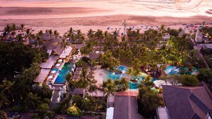 A resort with a swimming pool, beach, and palm trees. - Bali Mandira Beach Resort & Spa (Legian)