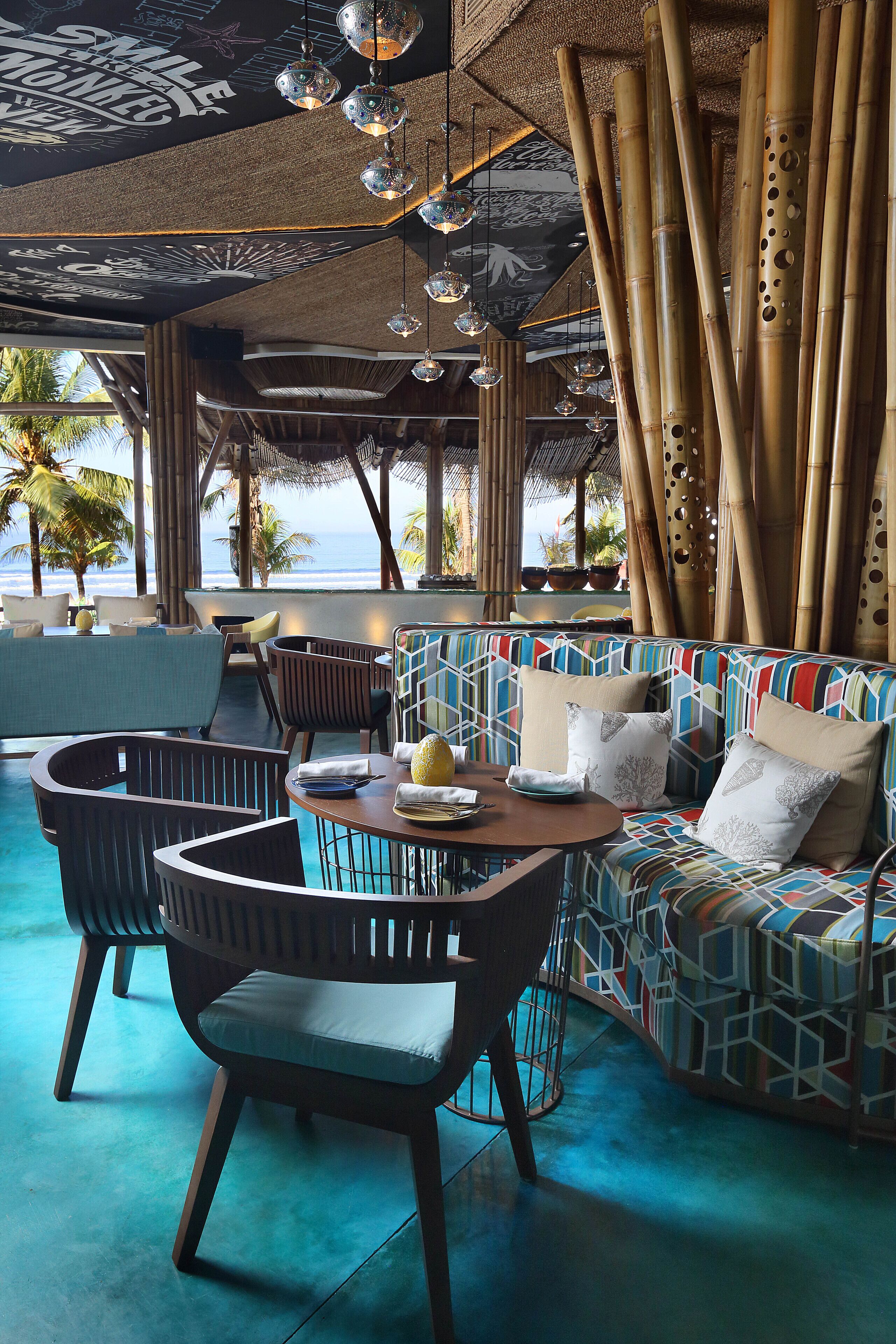 A lounge area with a sofa, chairs, and a table with a fruit bowl.