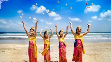 Una playa con cuatro personas vestidas con atuendos tradicionales coloridos.