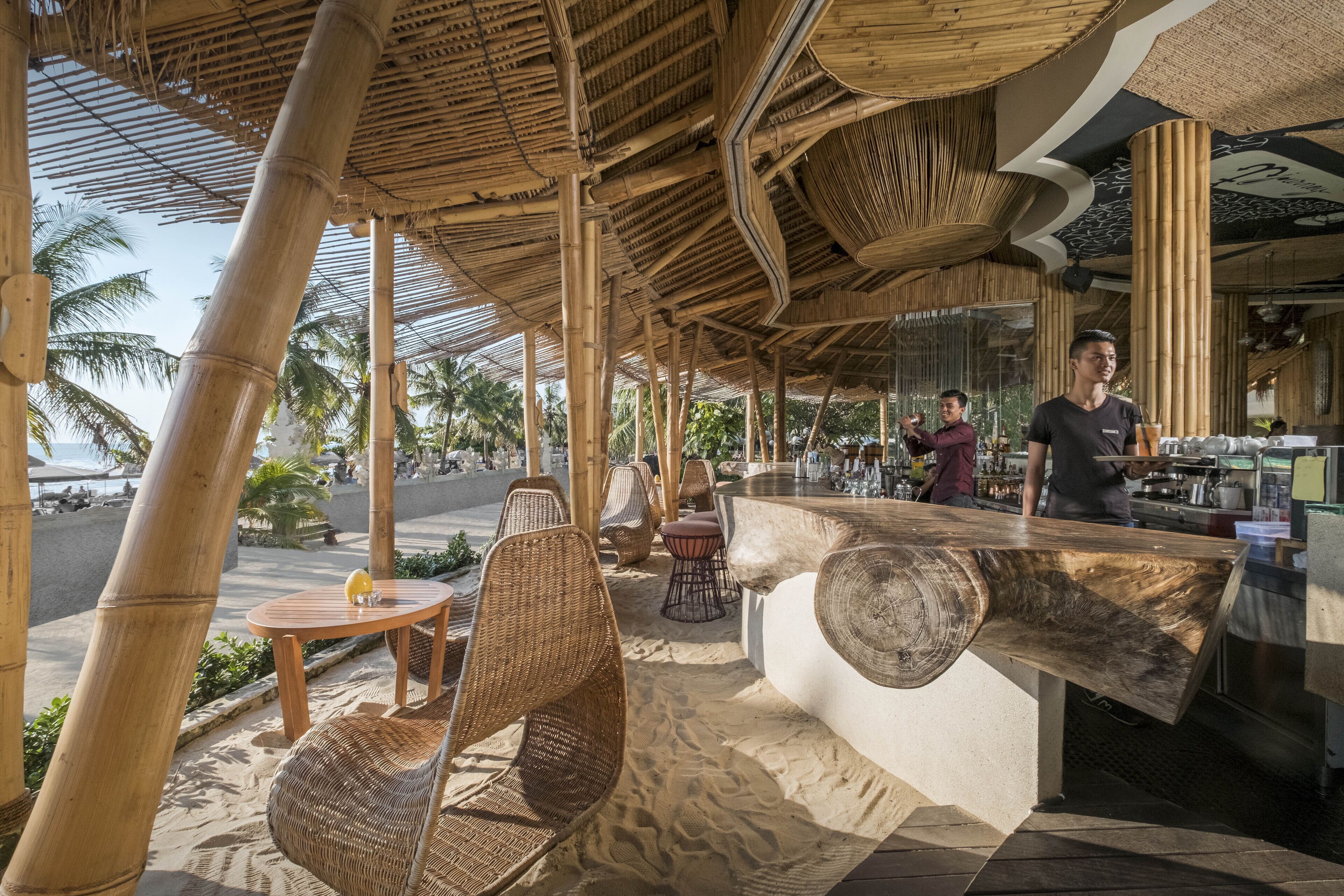 An outdoor seating area with bamboo furniture and a bar counter.