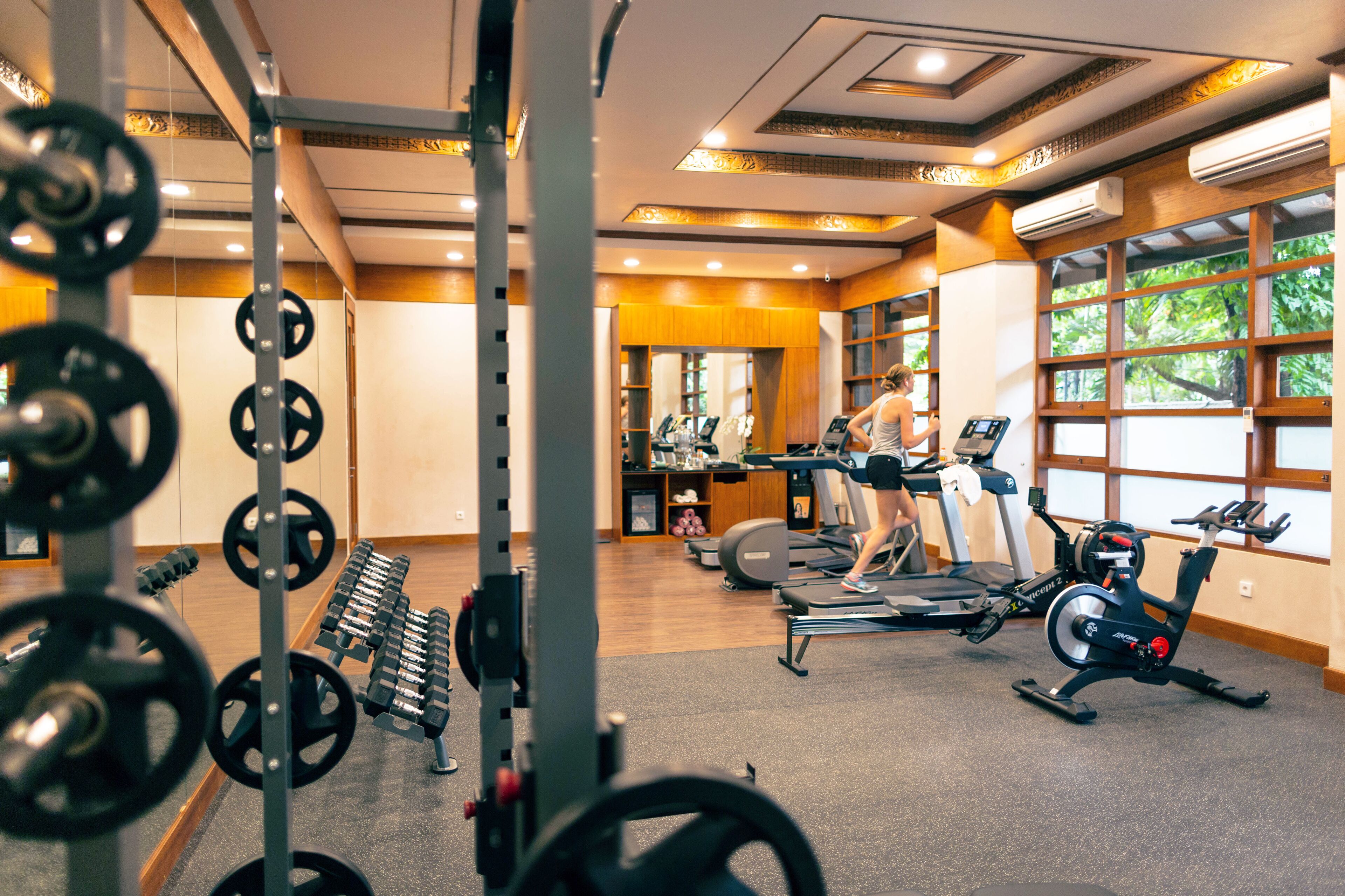 Una palestra con attrezzatura per sollevamento pesi, tapis roulant e cyclette.