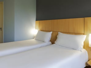 A hotel room with two single beds, a wooden headboard, and bedside lamps. - ibis Curitiba Aeroporto (Sao Jose dos Pinhais)
