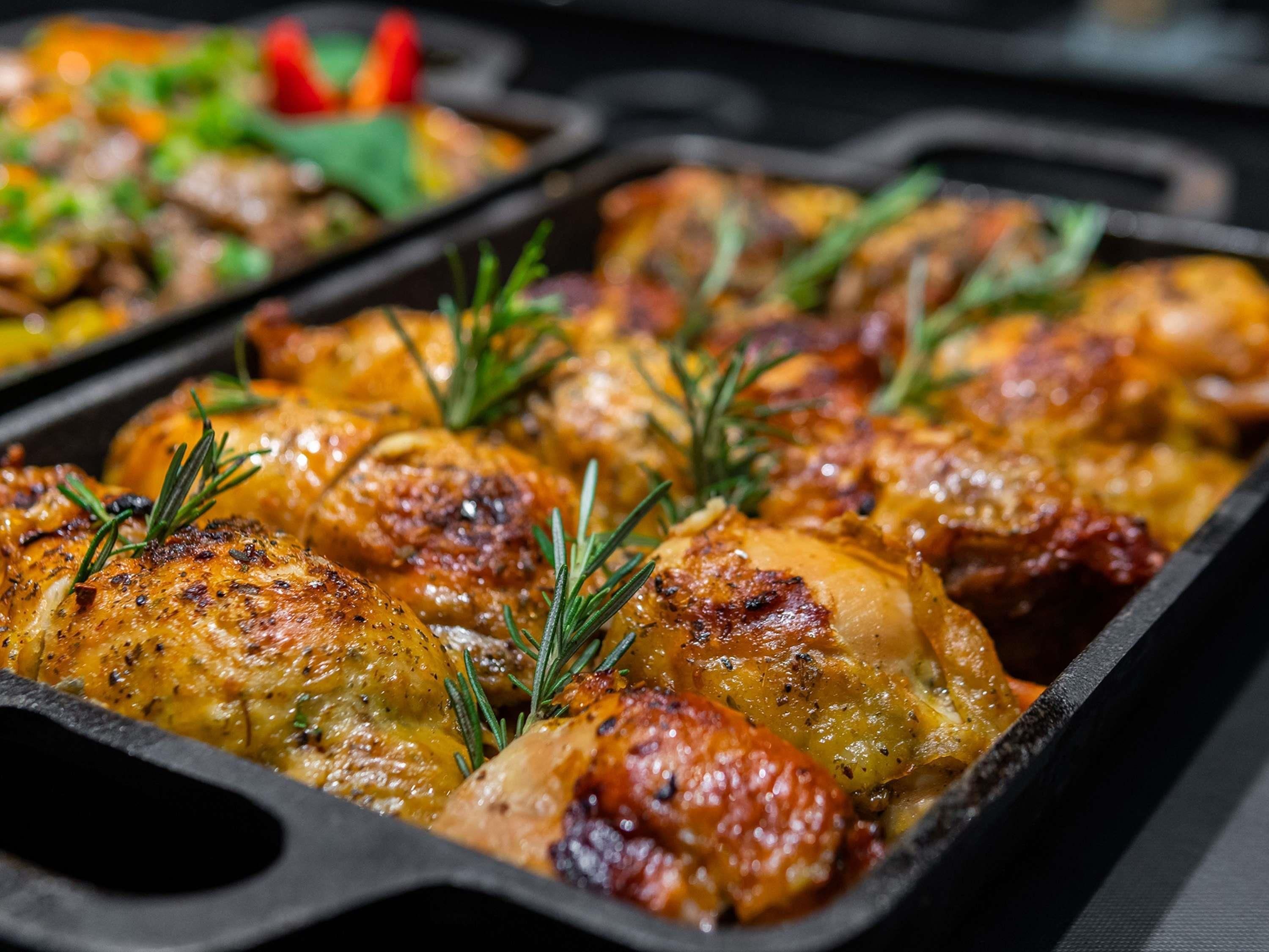 Un plat de poulet rôti, garni de romarin.