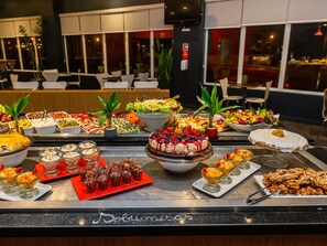 A buffet with various food items and a sign that reads 'Jubilee'. - ibis Curitiba Aeroporto (Sao Jose dos Pinhais)