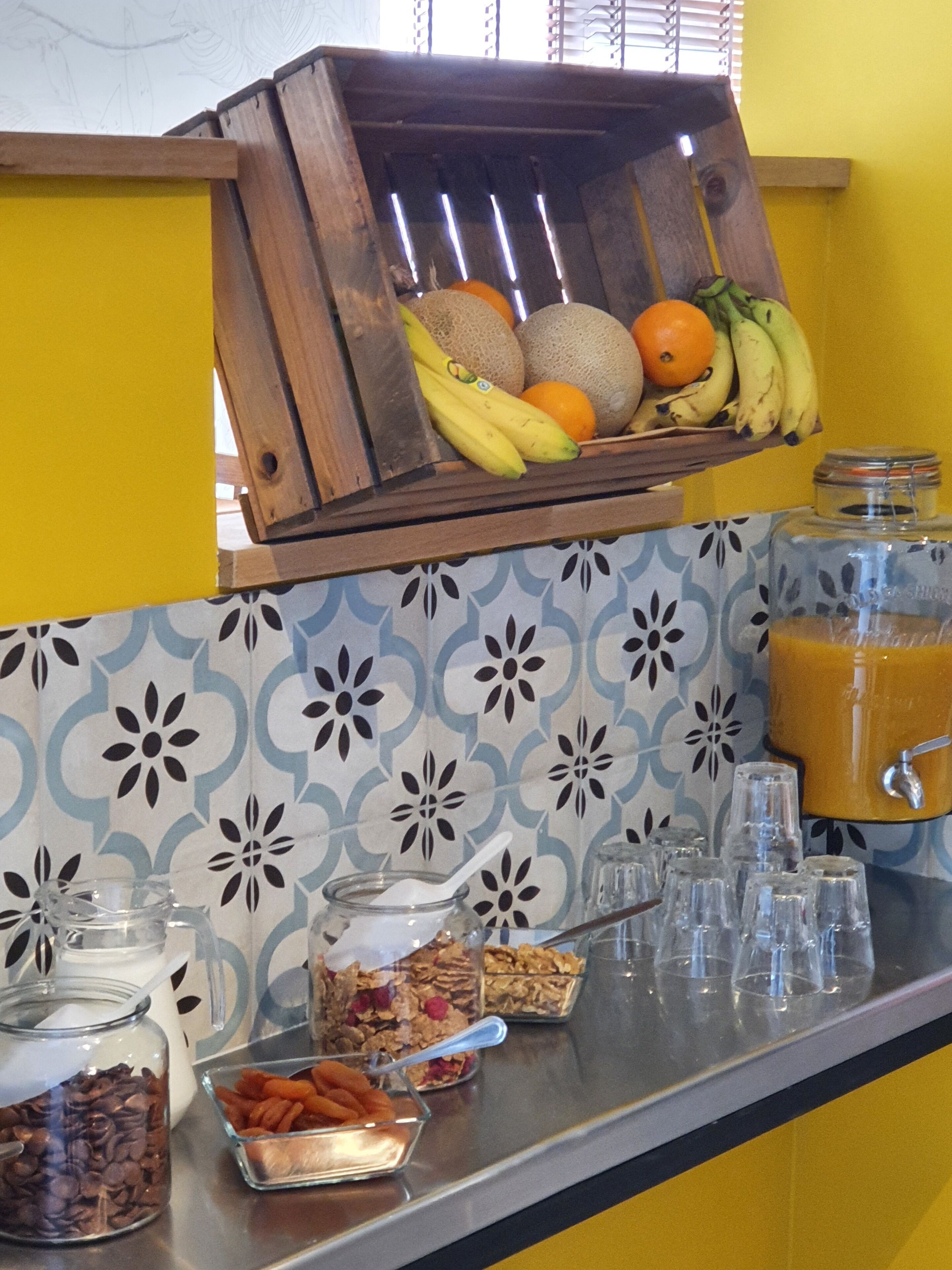 Een ontbijtbuffet met fruit, koffie, ontbijtgranen en sap.