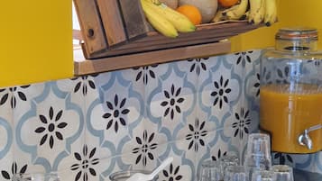 Een ontbijtbuffet met fruit, koffie, ontbijtgranen en sap.