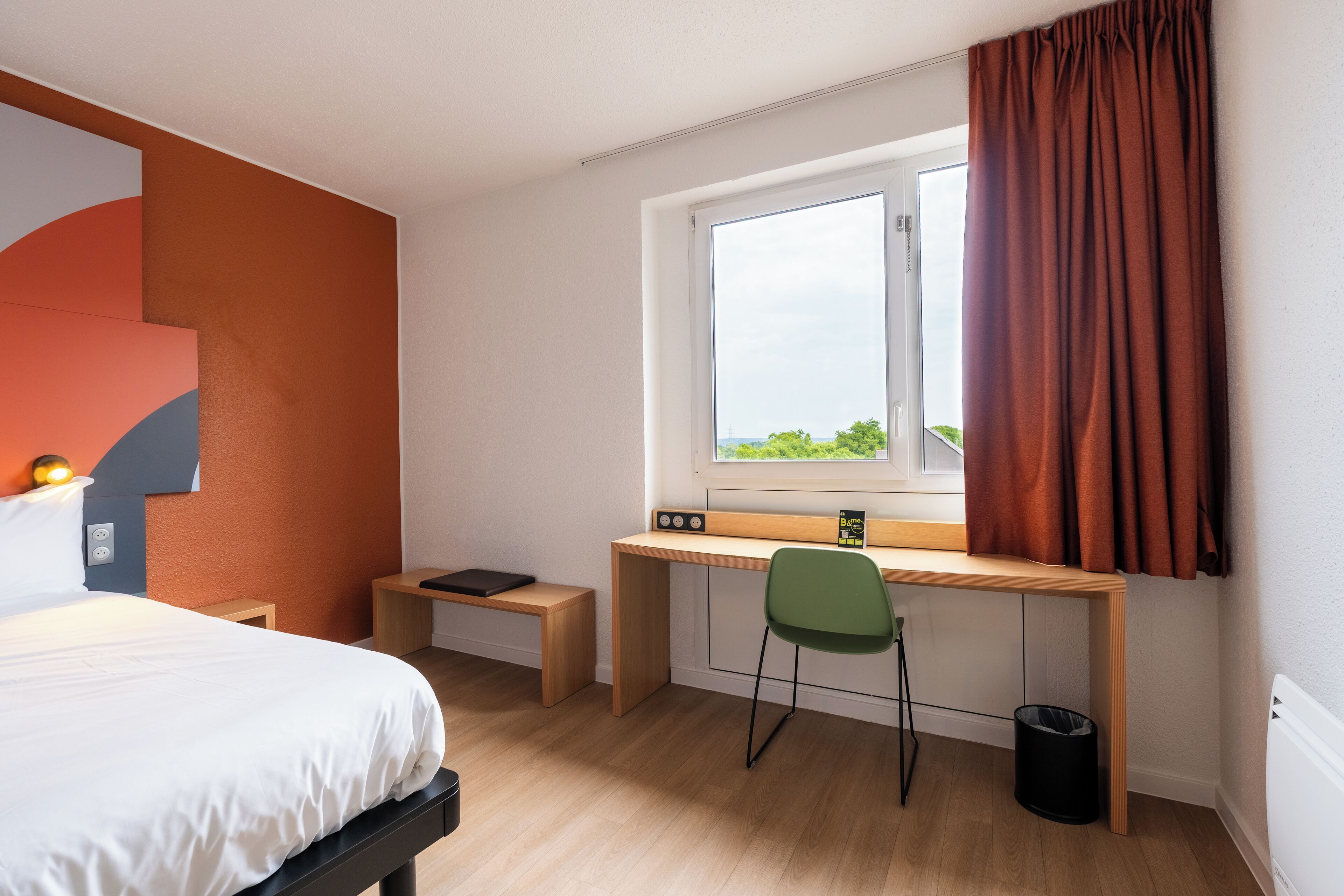 A modern bedroom with a bed, a desk, and a chair.