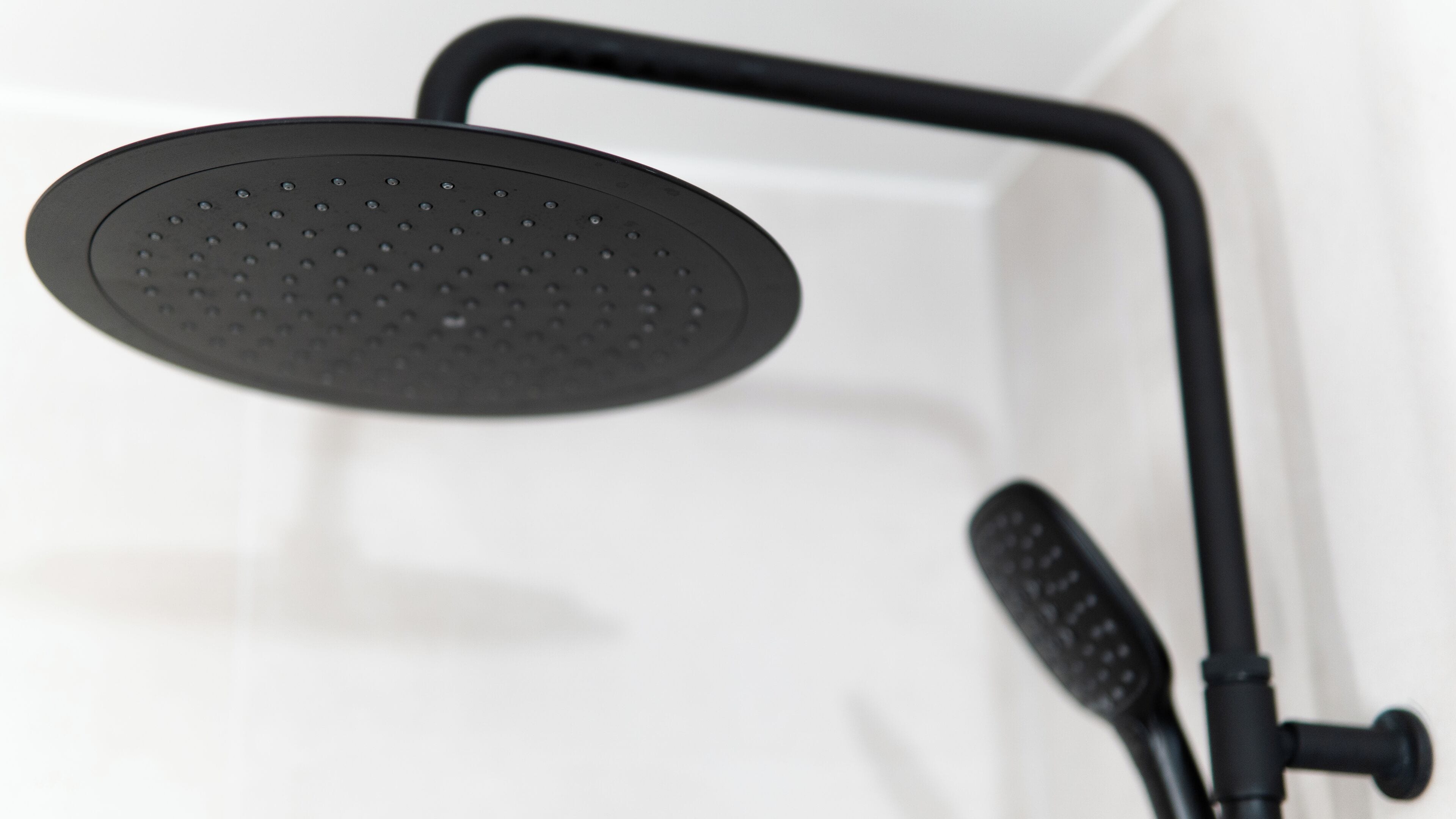 A showerhead with a curved design and a control knob.