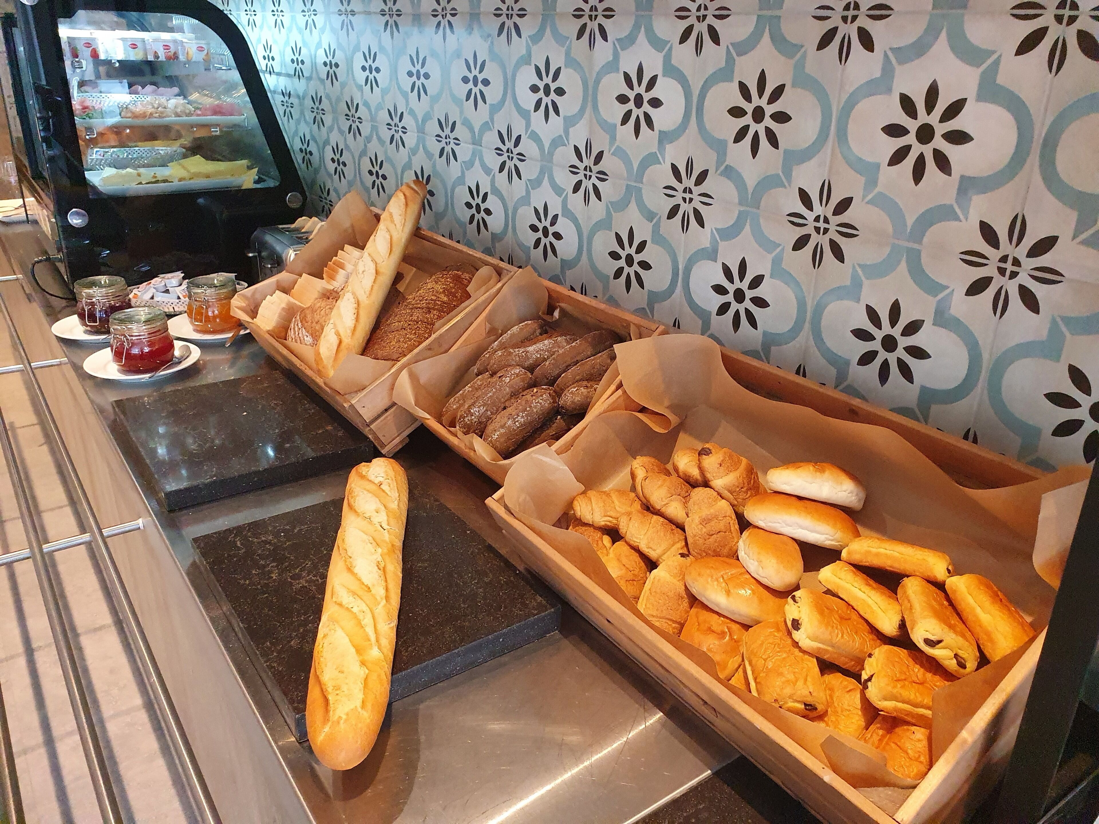 A bakery display with various breads and pastries.