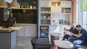 Un intérieur moderne comprenant un bar, des sièges et un réfrigérateur rempli de boissons.