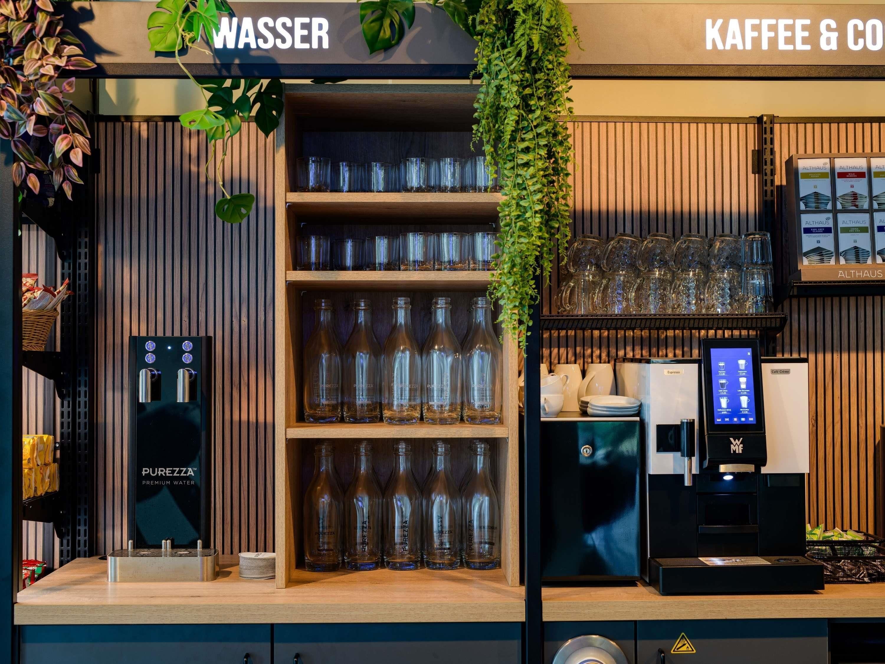 A coffee and water station with glassware and a water dispenser.