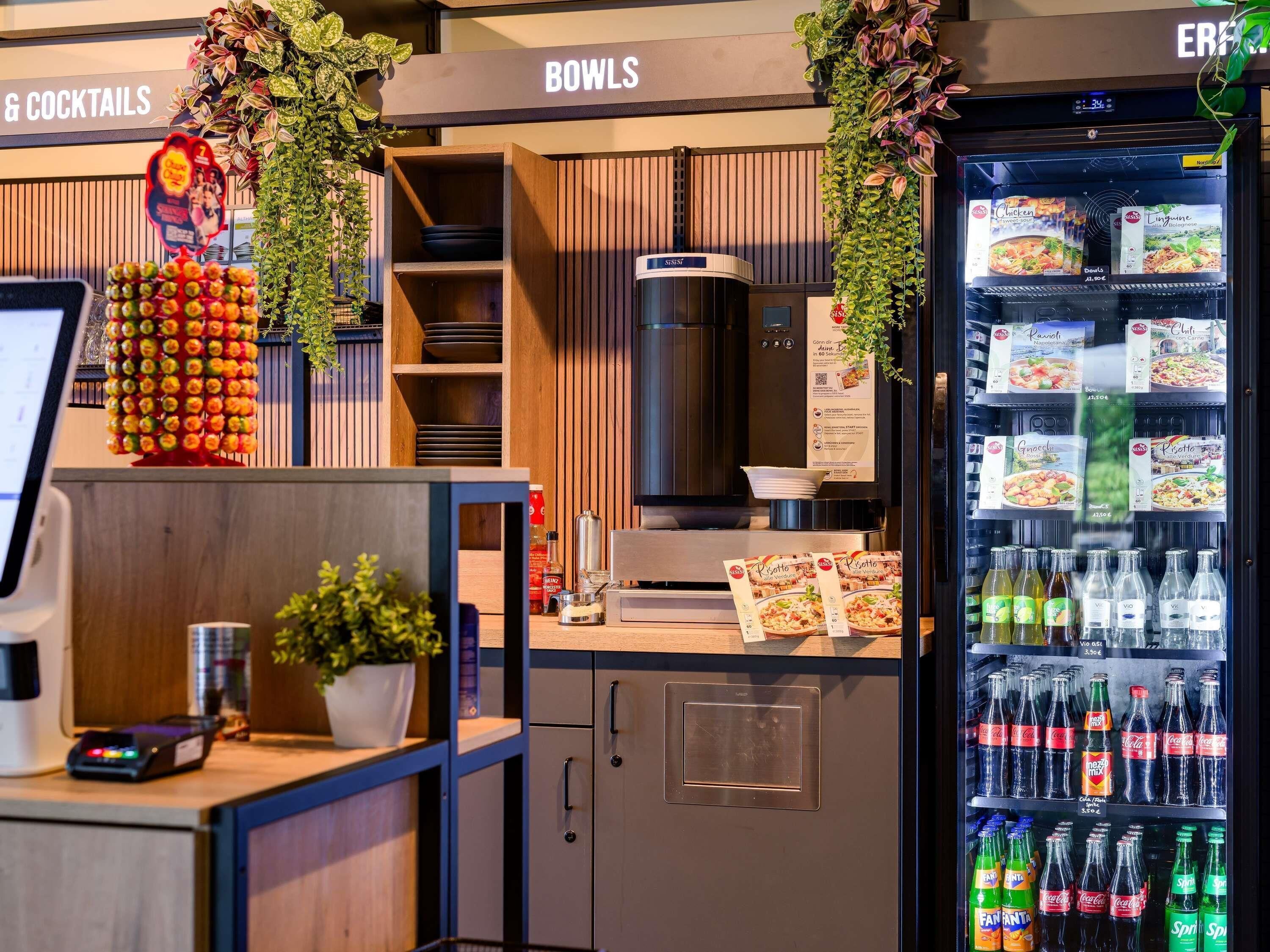 A self-service beverage station with a variety of drinks, a digital scale, and a menu display.