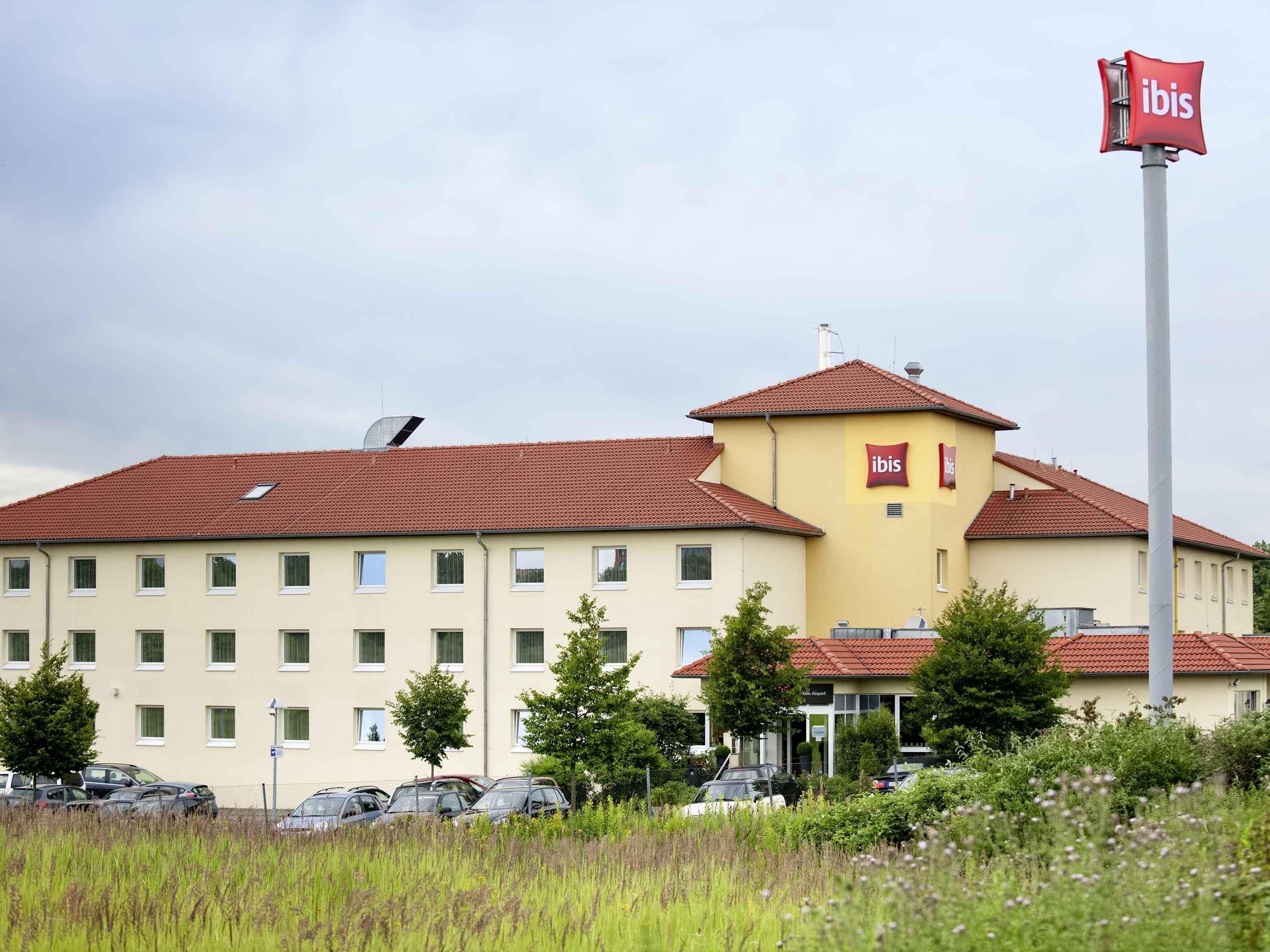 Un hotel con techo rojo y el logo de ibis bien visible.