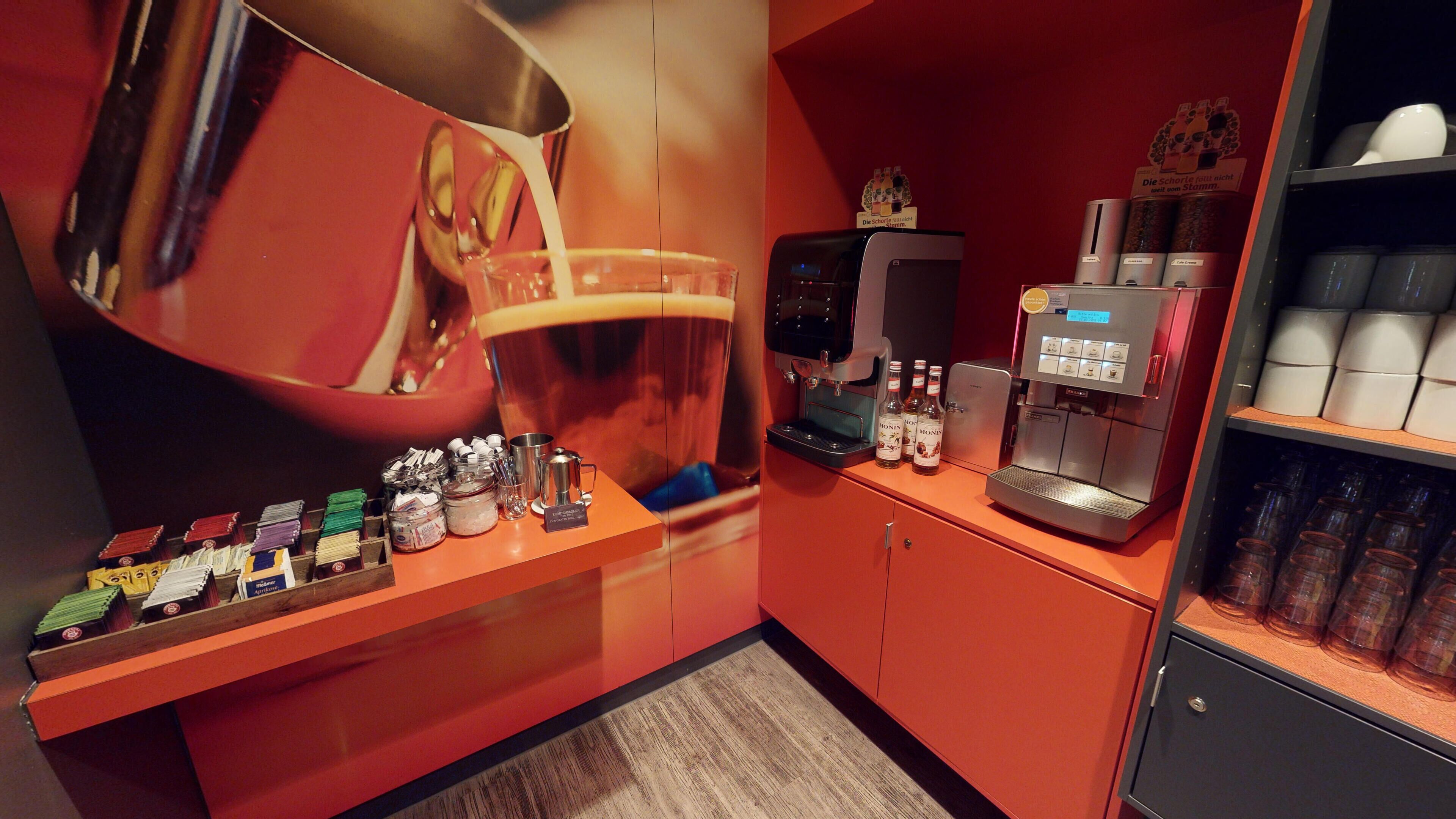 Un espace bar équipé d’une tireuse à bière, d’une machine à café et de diverses bouteilles.