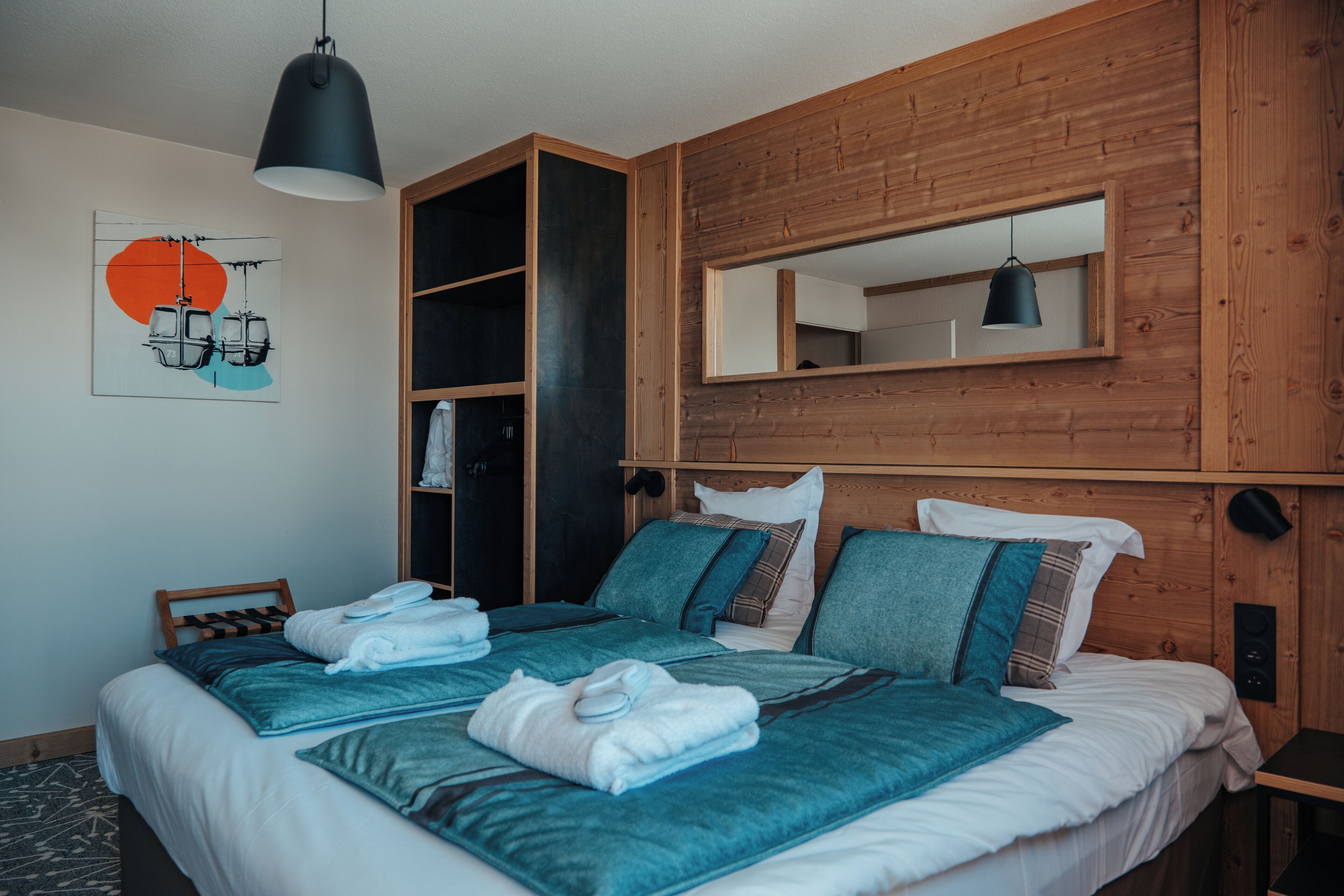A bedroom with a large bed, a built-in wardrobe, a mirror, and a ceiling light.