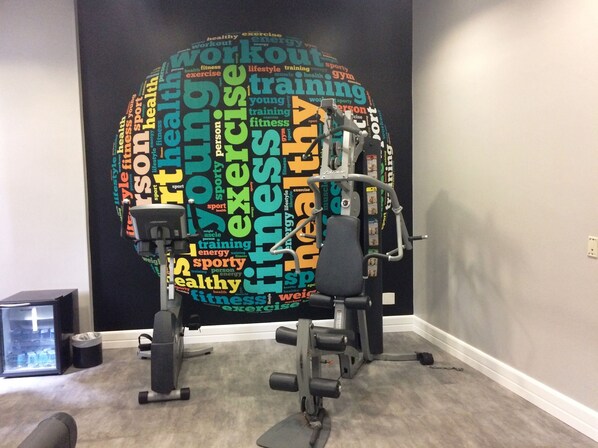 A home gym with a wall-mounted exercise machine and free weights. - Mercure São Paulo Paulista Hotel (São Paulo)