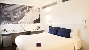A hotel room with a bed, desk, chair, and a large poster on the wall. - Mercure São Paulo Paulista Hotel (São Paulo)