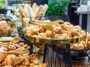 A variety of baked goods including pastries and bread, arranged on a table with a metal tray. - Mercure São Paulo Paulista Hotel (São Paulo)