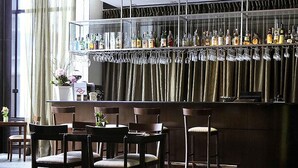 A bar area with wooden chairs and a bar counter displaying various bottles. - Mercure São Paulo Paulista Hotel (São Paulo)