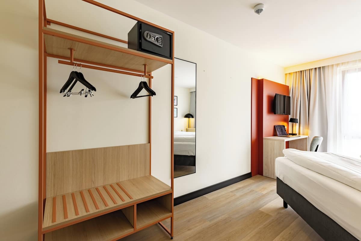 Ropa de cama hipoalergénica y caja de seguridad en la habitación