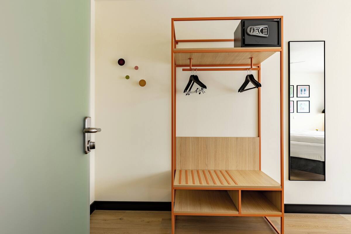 A bunk bed with a wooden frame, a small shelf, and a safe on top.
