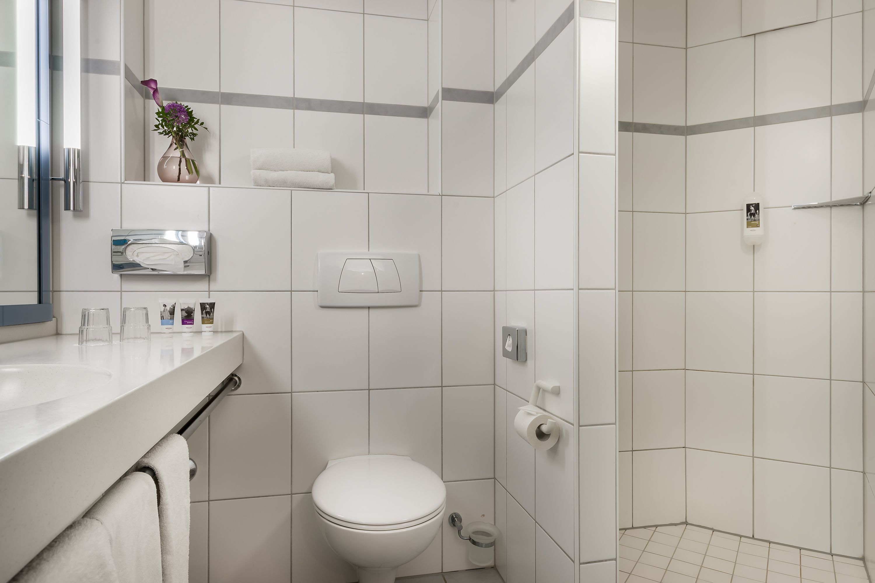 Ein modernes Badezimmer mit Toilette, Waschbecken und Dusche.